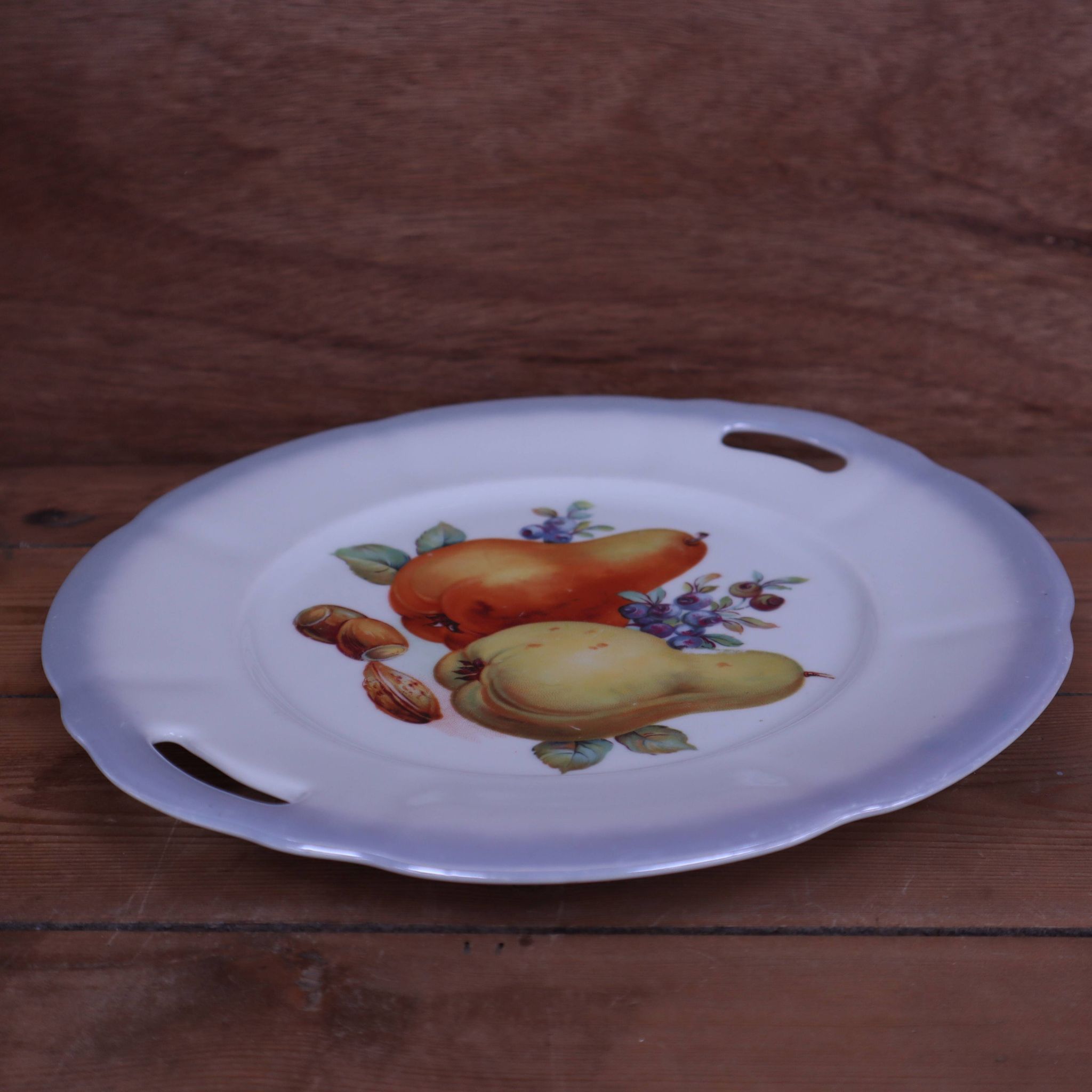 Set of 7 dessert plates and a cake stand with fruit patterns.
