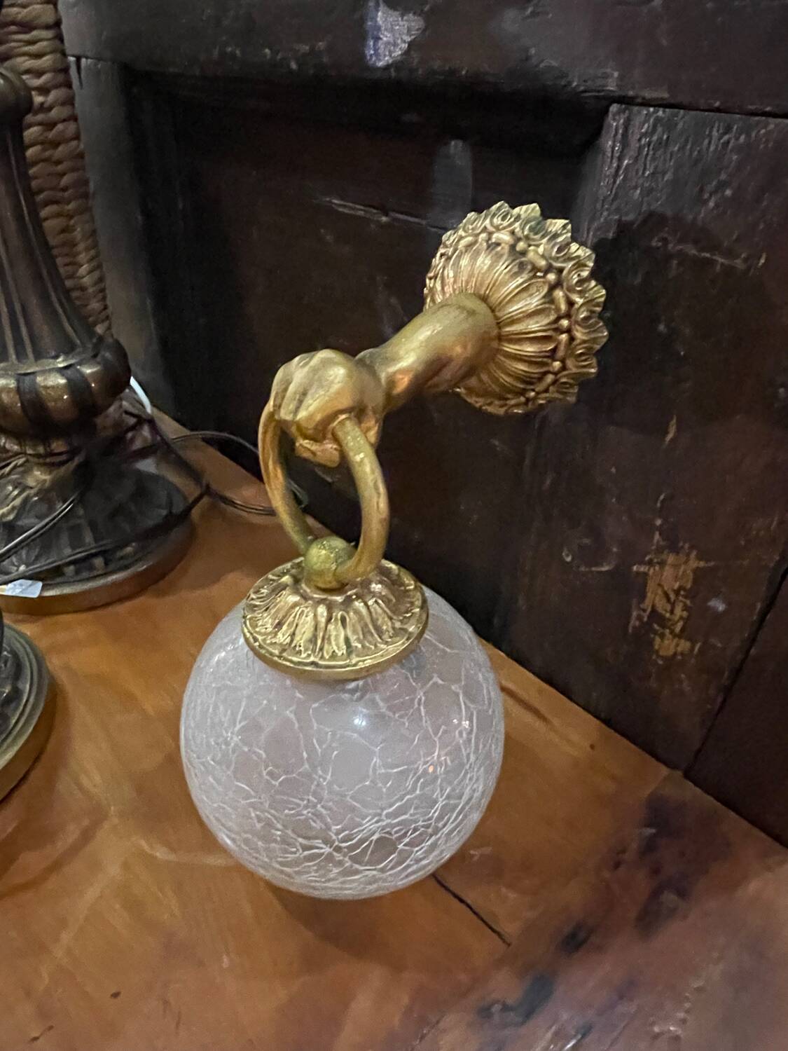 Vintage wall light in gilded bronze with a cracked glass globe.