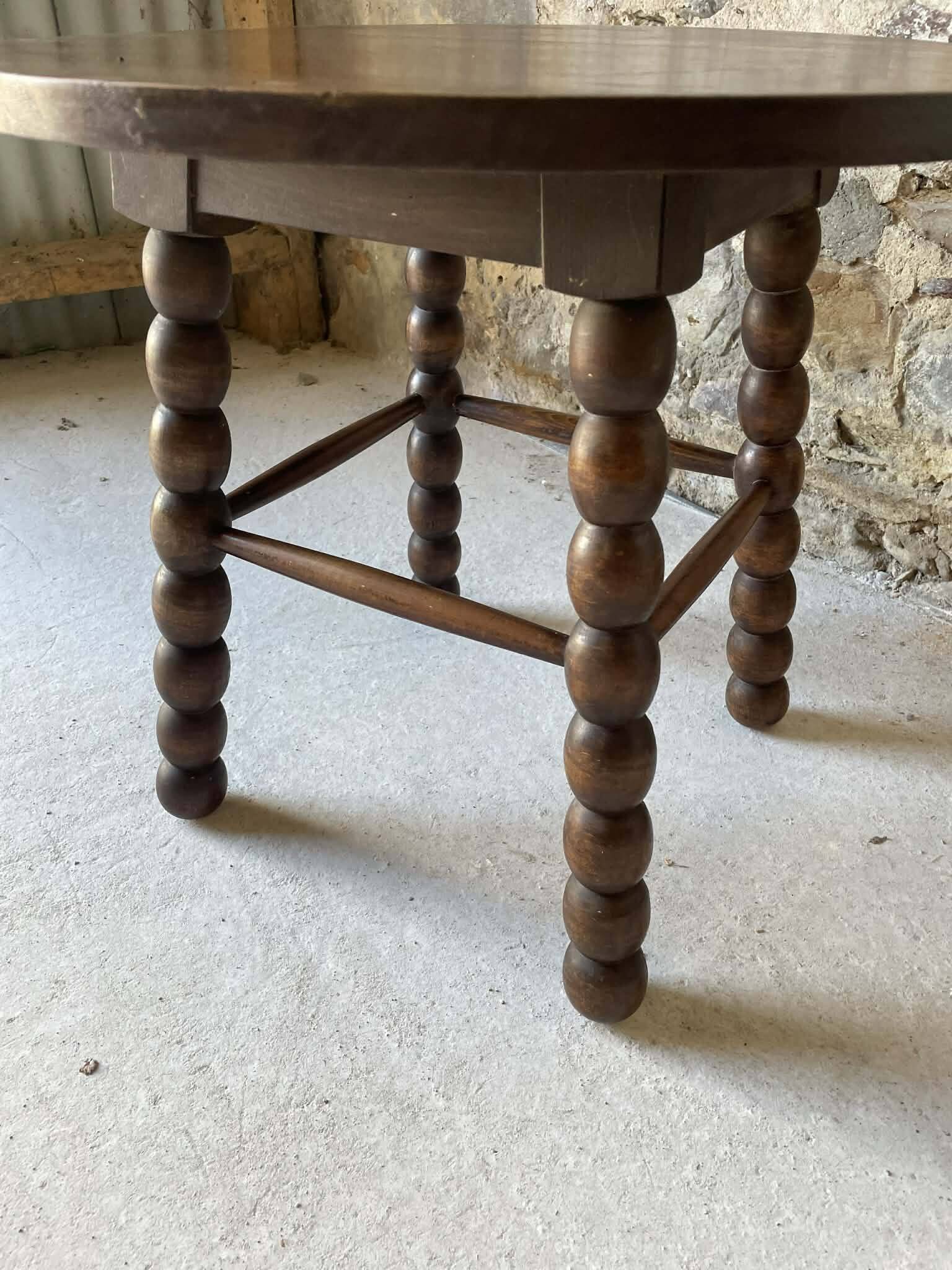 Round wooden coffee table with turned legs.