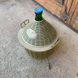 Large green glass lady-Jeanne in a khaki plastic basket, mid-century style.