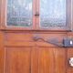 Oak entrance door and its frame and transom, wrought iron gates