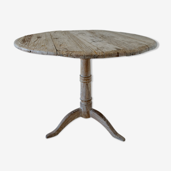 Round table with patinated raw wood fellers