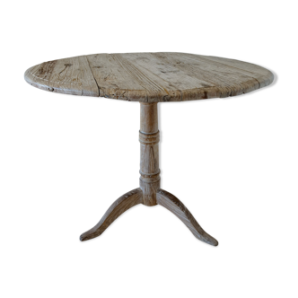 Round table with patinated raw wood fellers