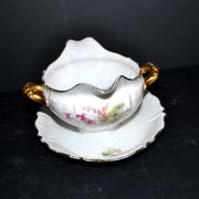 Vintage pouring sauce boat in floral porcelain with gilding.