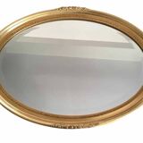 Beveled oval mirror with carved gilded wood frame