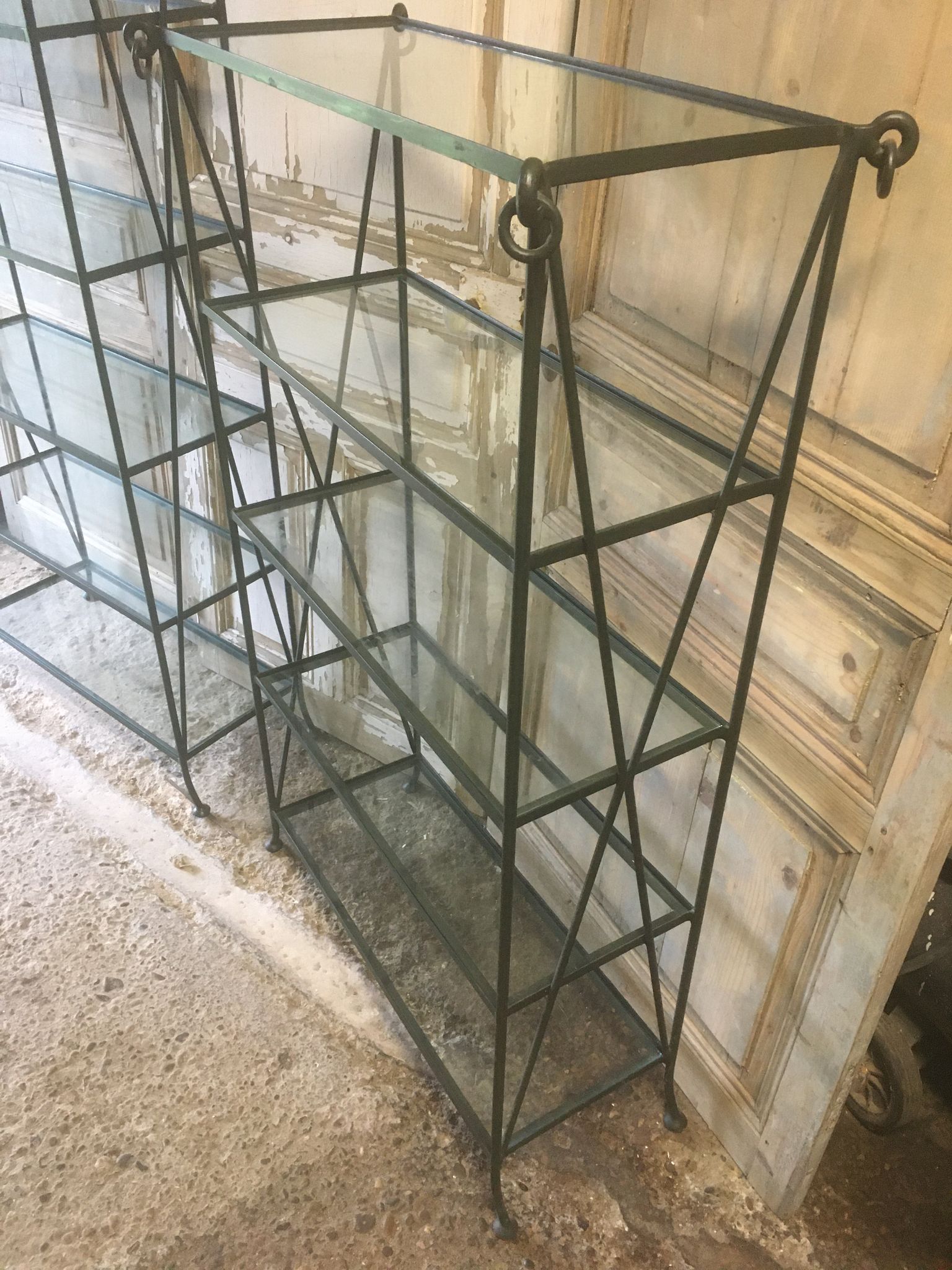 Pair of wrought iron and glass bookshelf shelves.