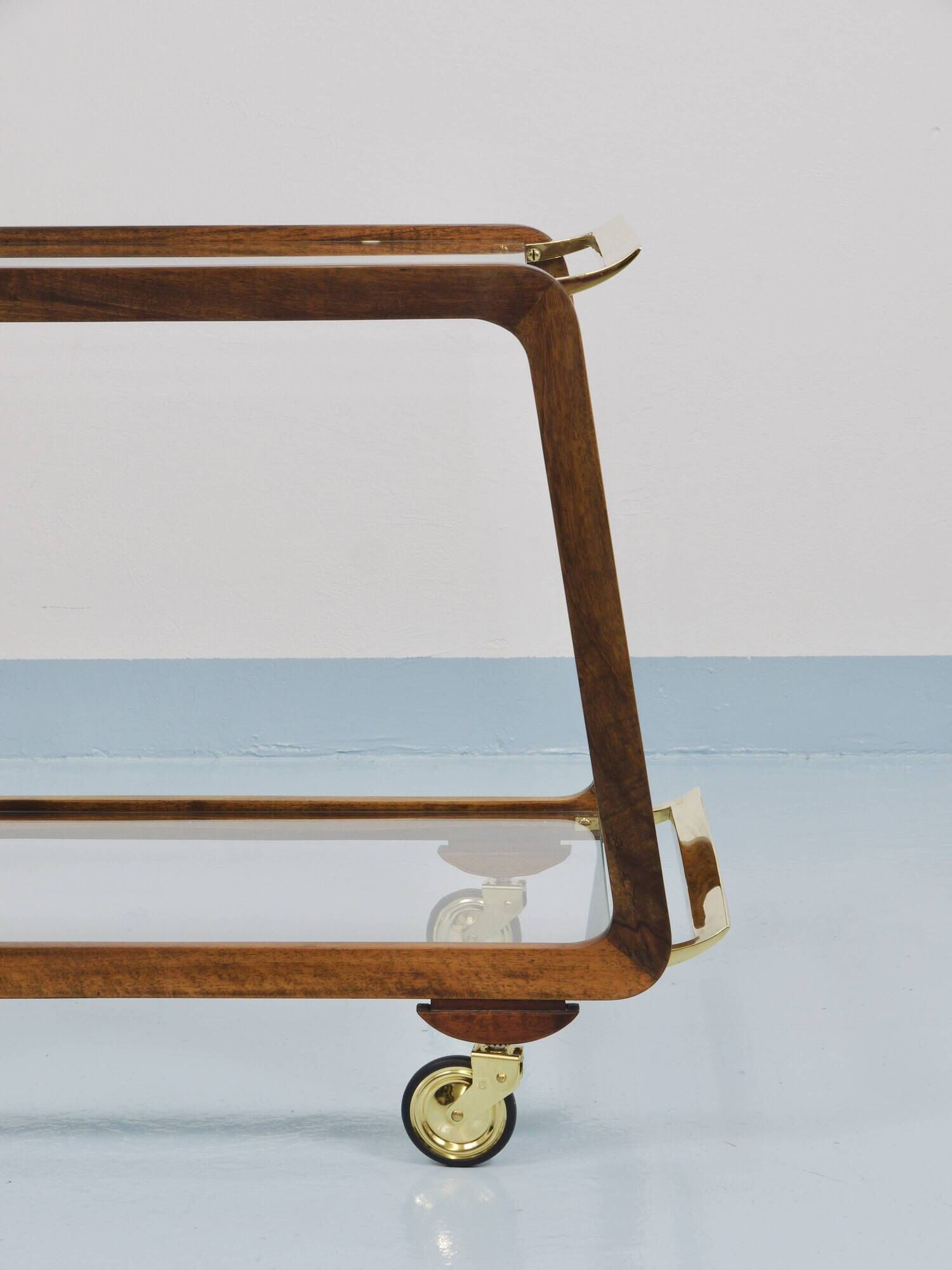 May include: A mid-century modern bar cart with a dark wood frame and two c