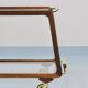 May include: A mid-century modern bar cart with a dark wood frame and two c
