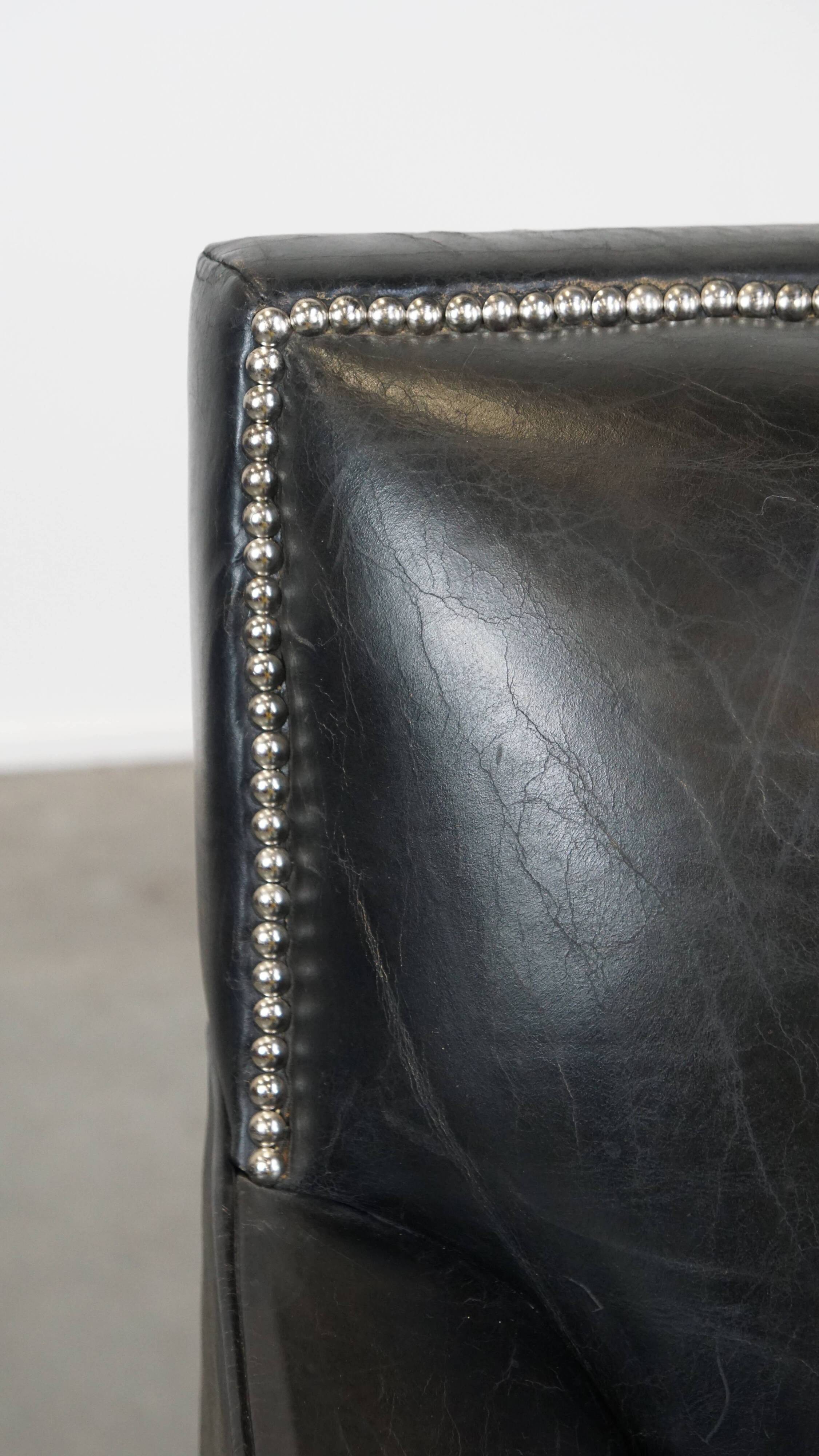 Armchair in black grained cowhide leather with a deep seat