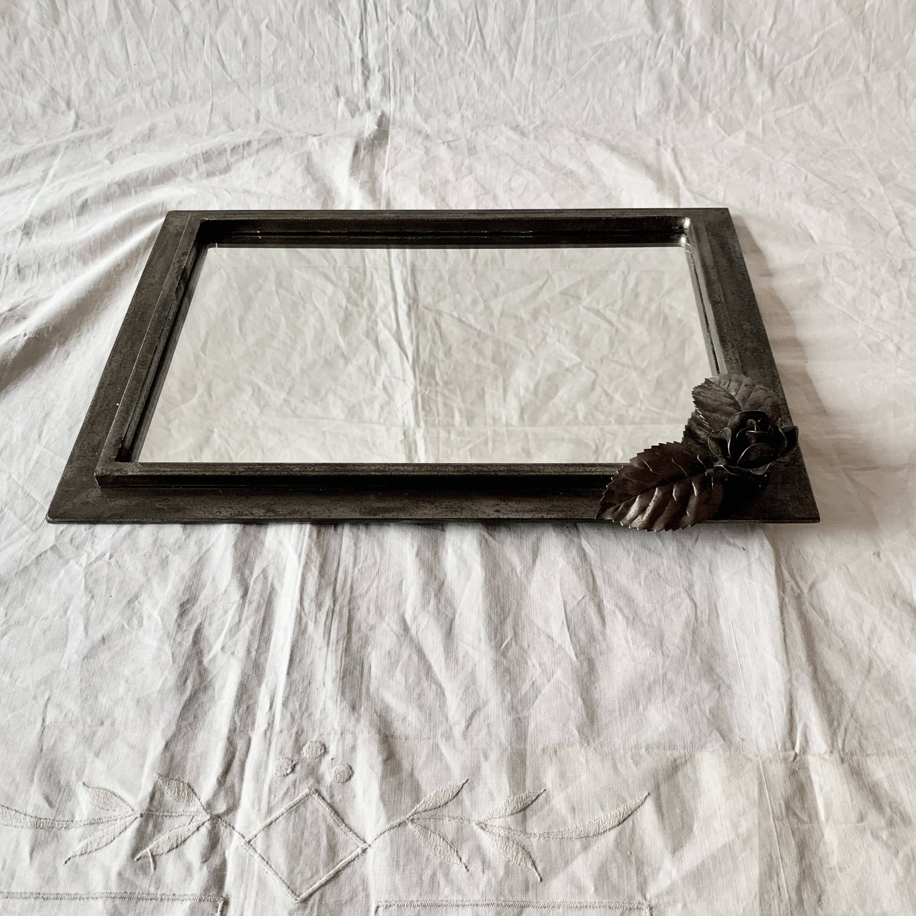 Vintage wall mirror in varnished steel decorated with a rose in relief