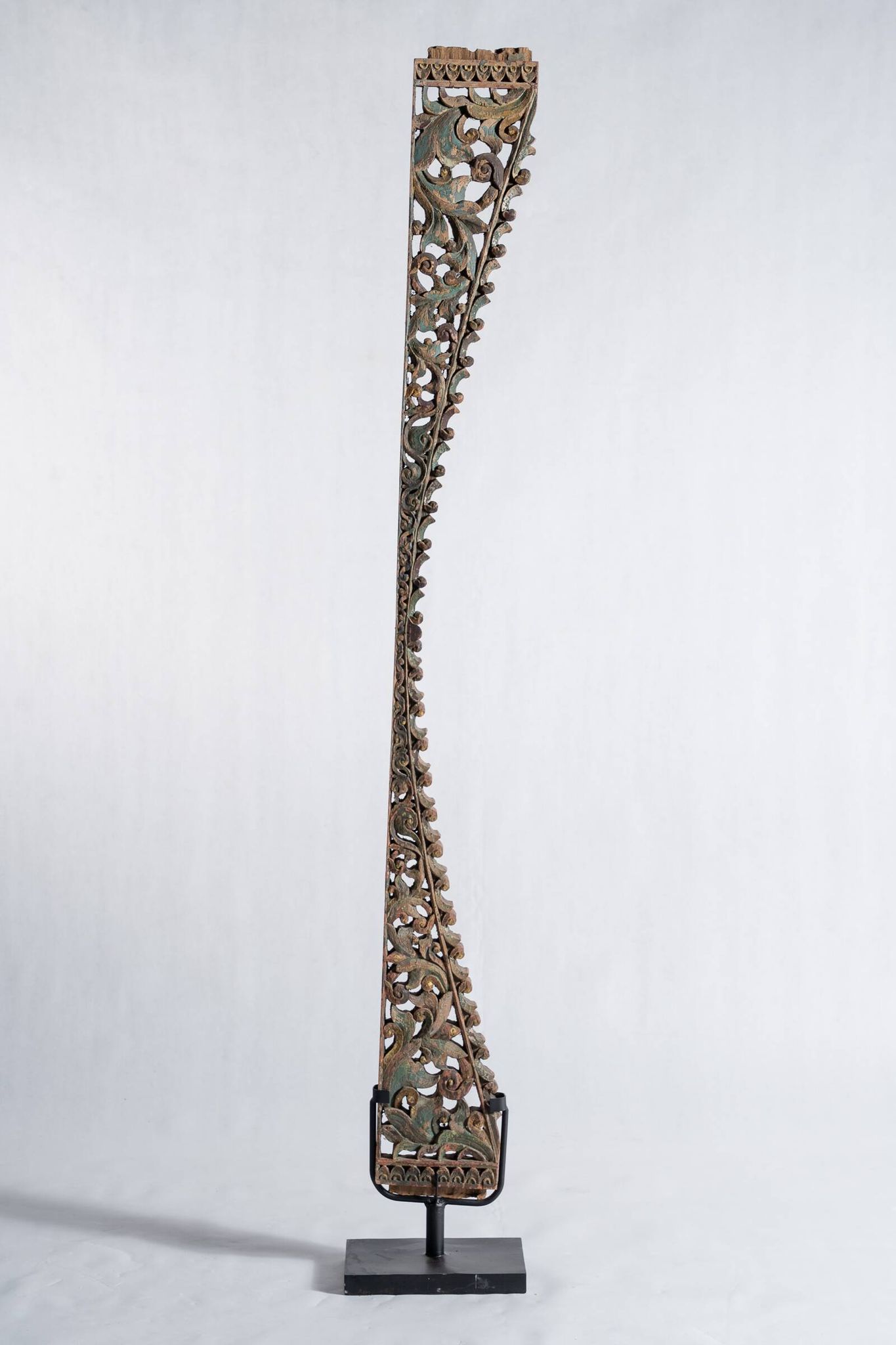 Indonesian construction element in carved wood with intertwined plant motifs mounted on a base (fri