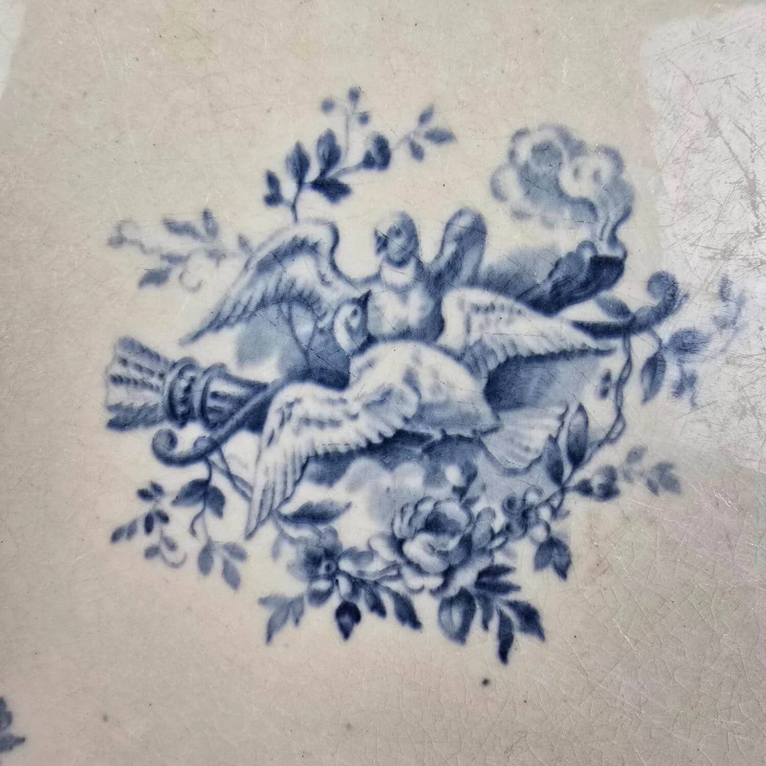 Old Gien plate with carved edges featuring doves and blue flowers, circa 1920-1930.