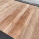 Large extendable round dining table stripped in solid cherry wood with a central leg.