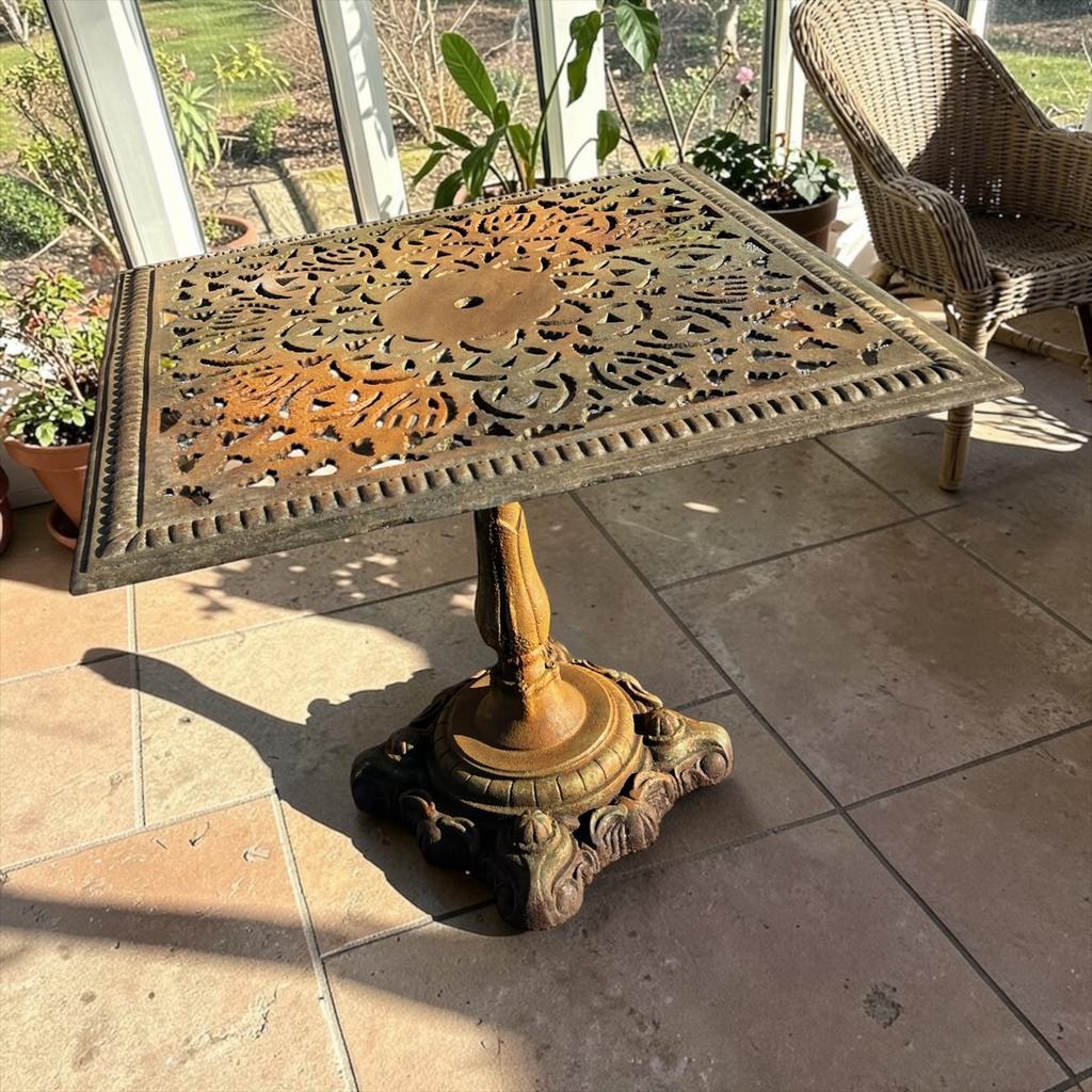 Antique cast iron garden table with decorative openwork top.