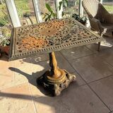 Antique cast iron garden table with decorative openwork top.