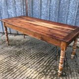 Antique farmhouse table in solid cherry wood with turned legs.
