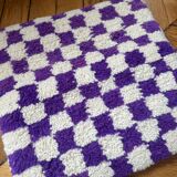Square cushion cover with a checkered pattern.
