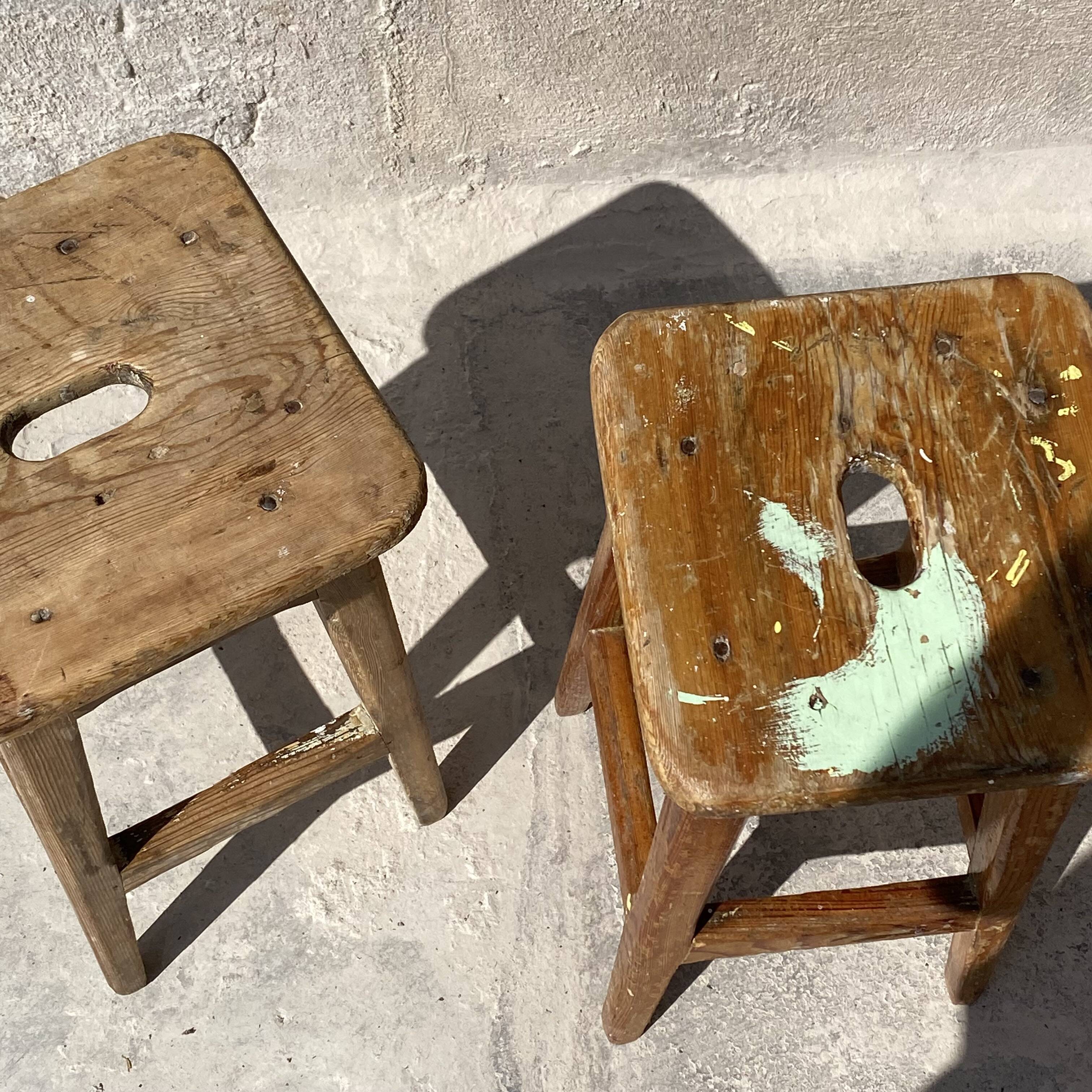 Pair of vintage wooden workshop stools with a patina.