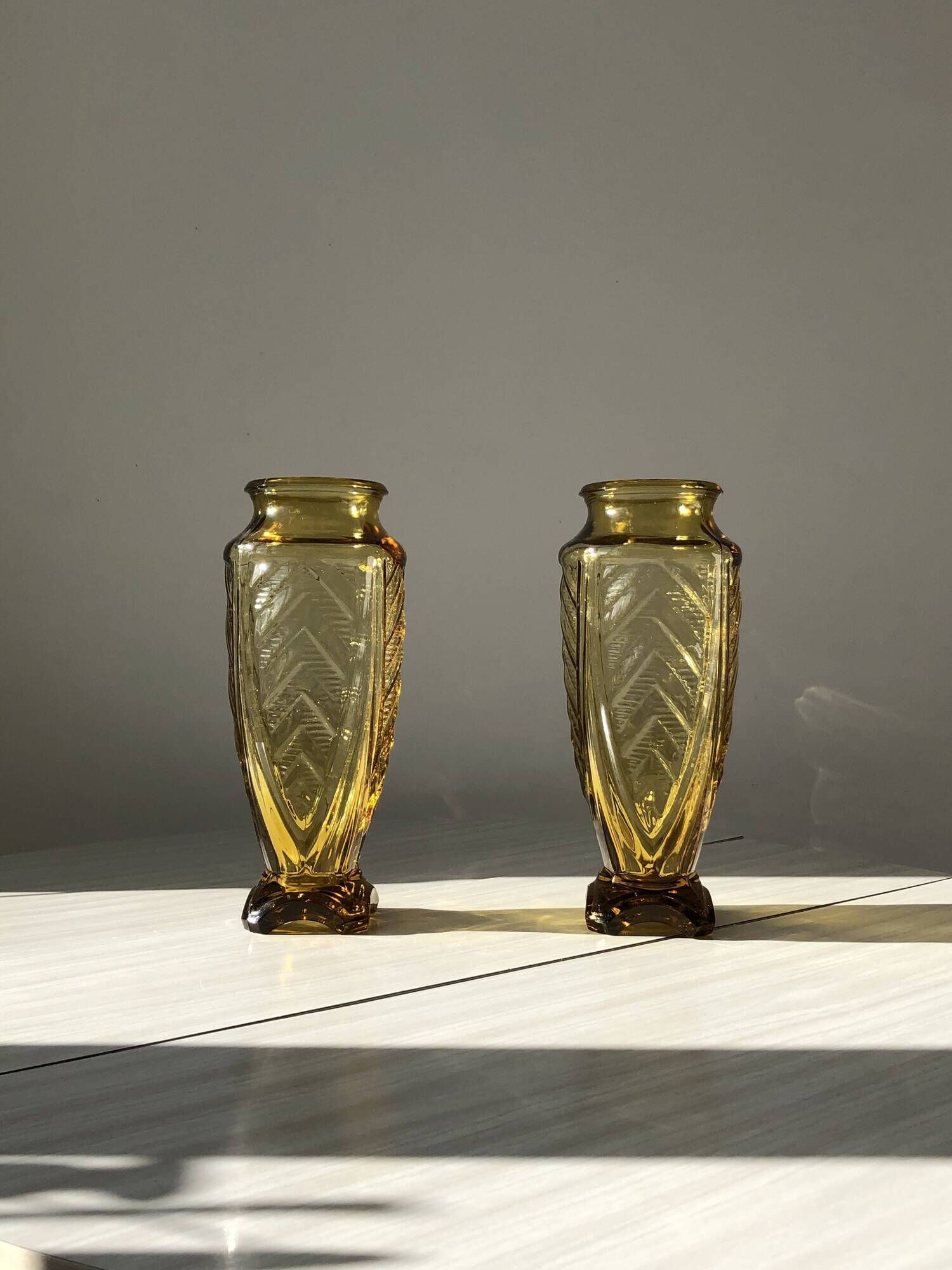 Duo of art deco vases in yellow glass with scroll patterns