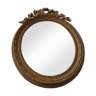 Old oval wooden mirror, surmounted by a knot