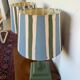 Pair of vintage wooden lamps with their striped beige, blue, and green shades.