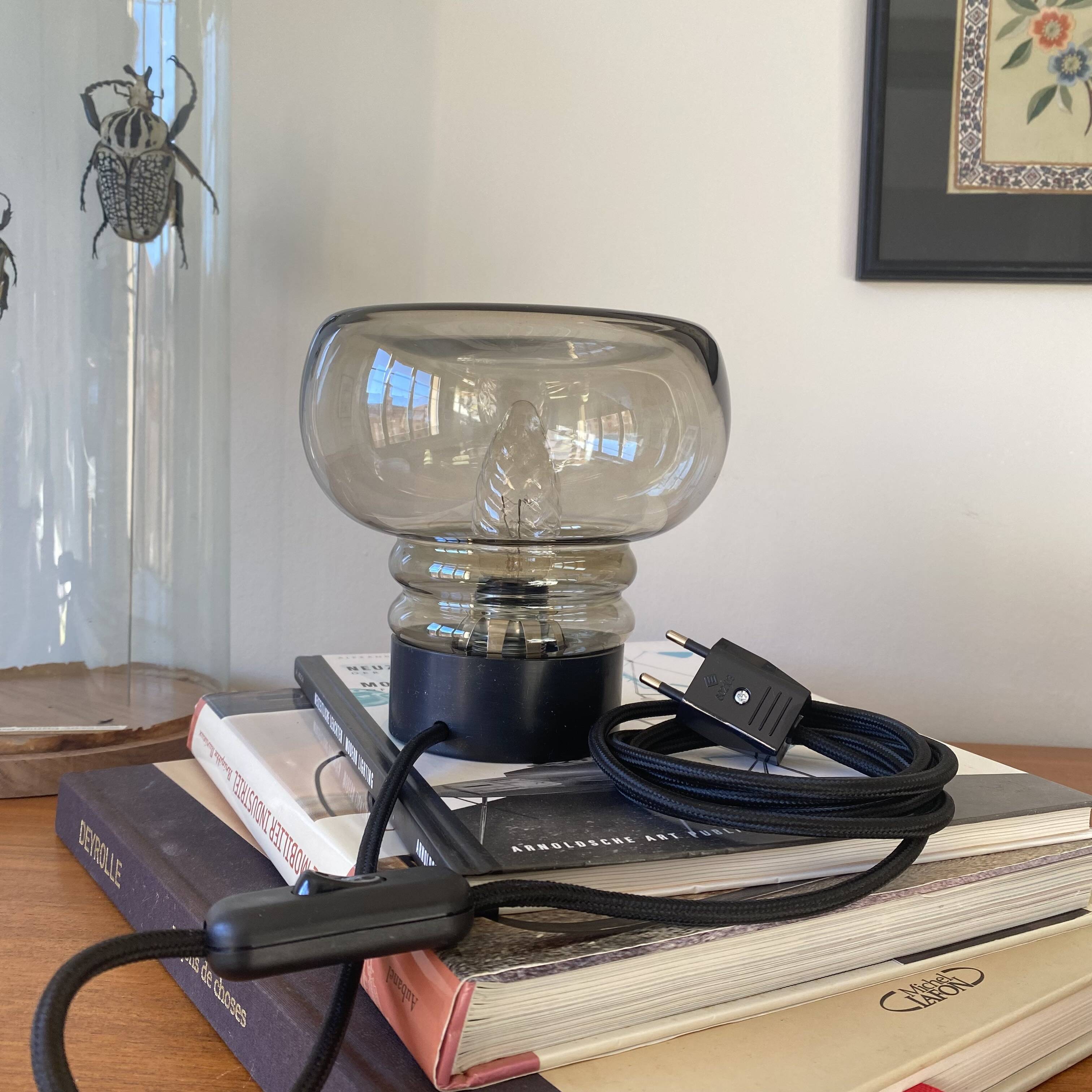 Sciolari table lamp with smoked glass globe and black plastic base.