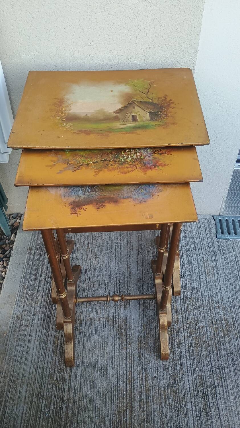 Sets of three nesting tables with painted landscape decorations in poplar.