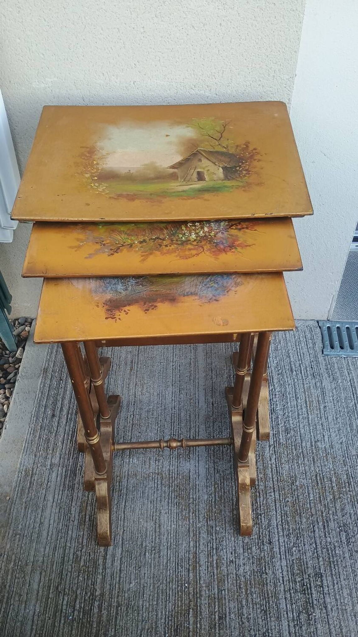 Sets of three nesting tables with painted landscape decorations in poplar.