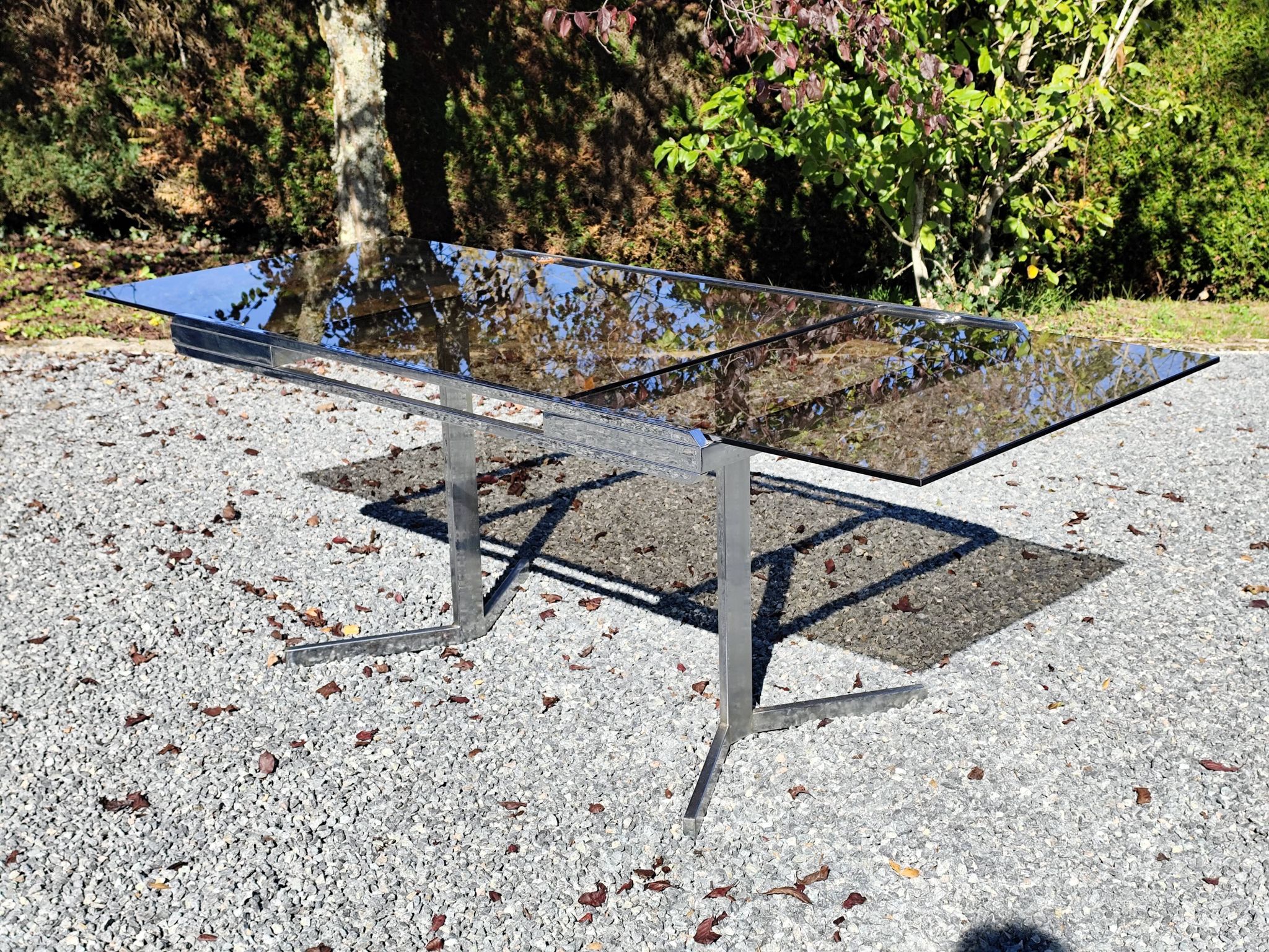 Table pietement chromé et verre fumé année 70 avec allonges