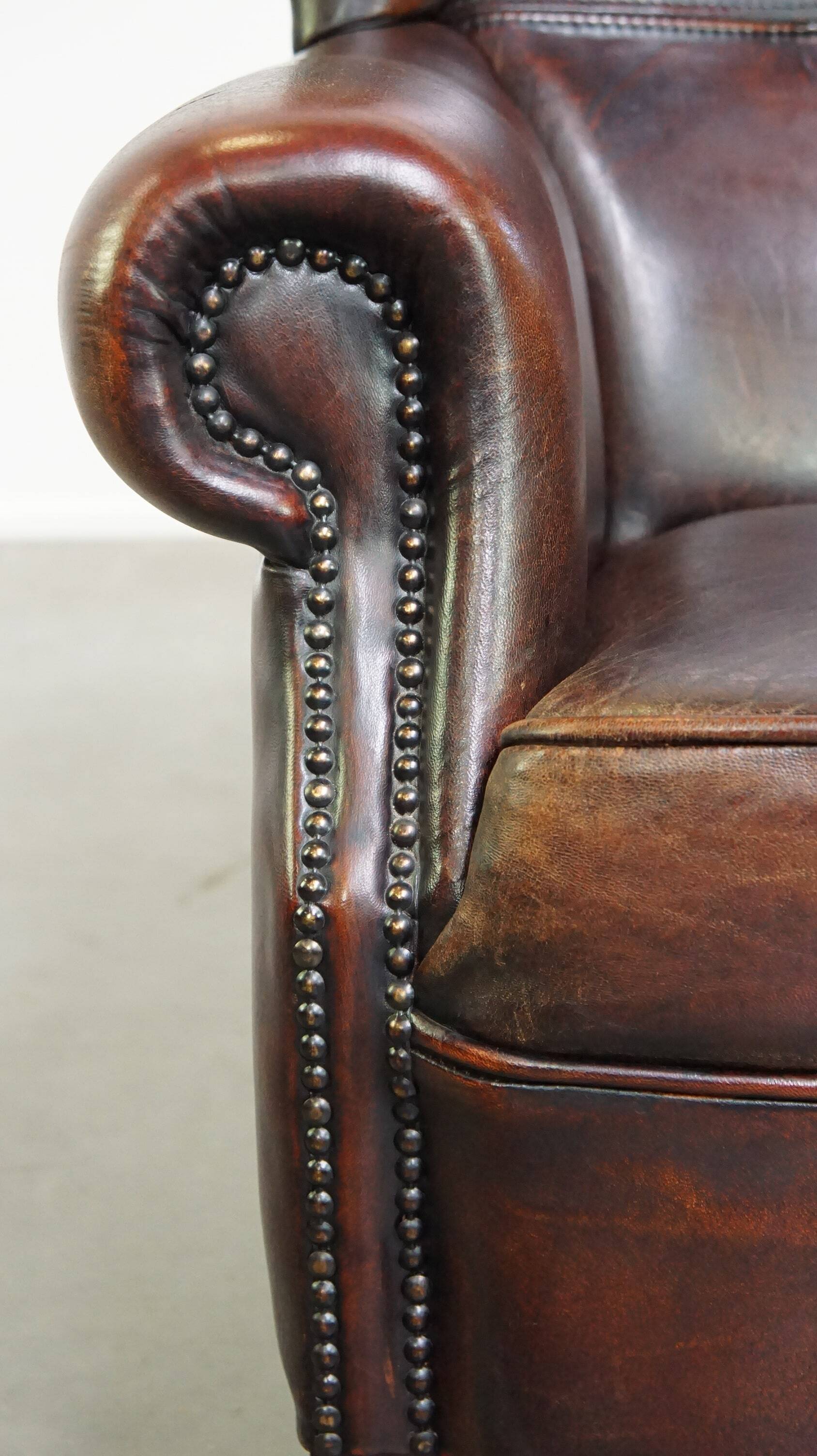 Fauteuil à oreilles confortable et bien entretenu en cuir de mouton