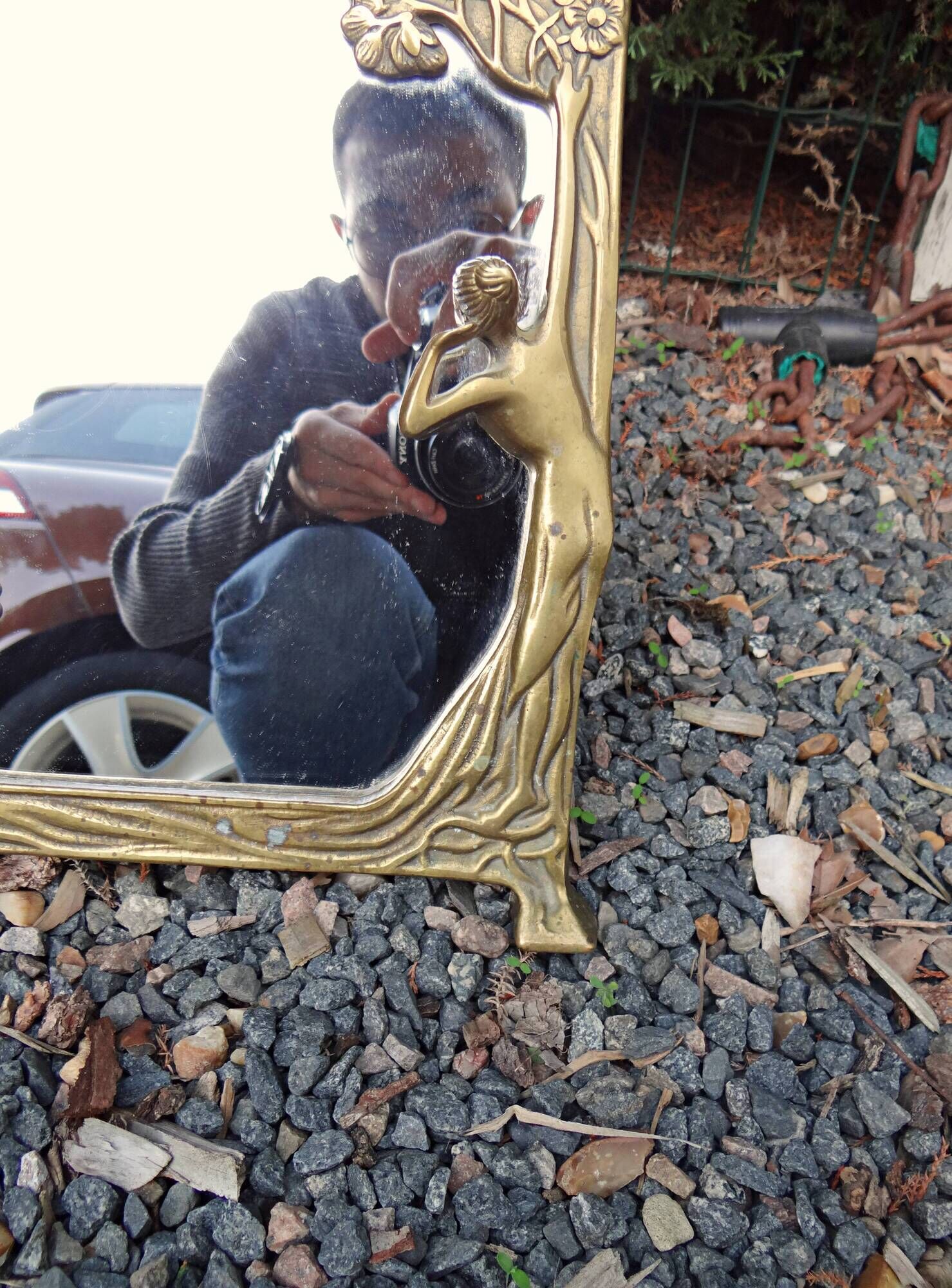 Art Nouveau mirror in gilded brass with a woman figure emerging from a vintage frame