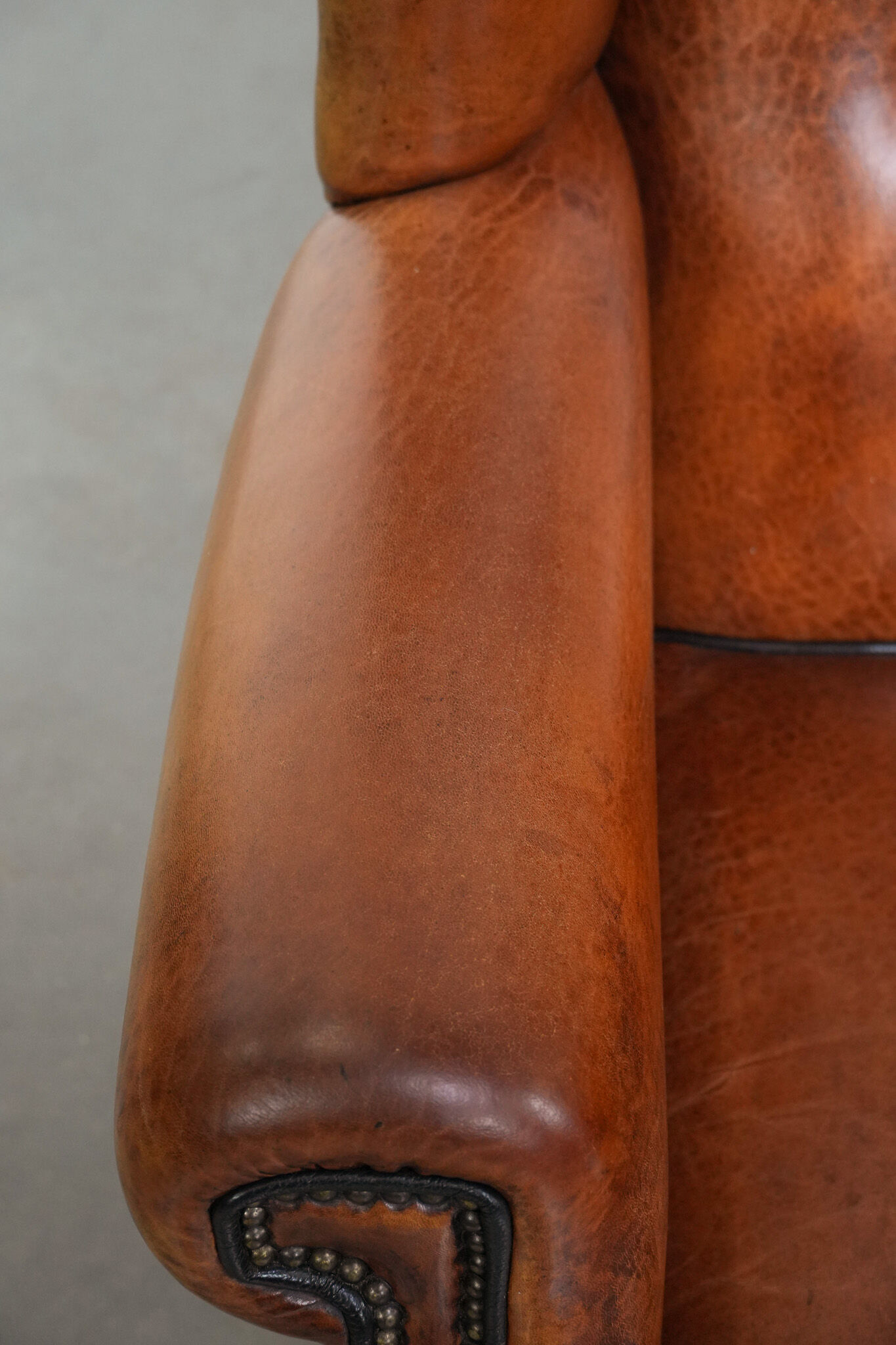 Wingback chair made of sheep leather with black piping in good condition