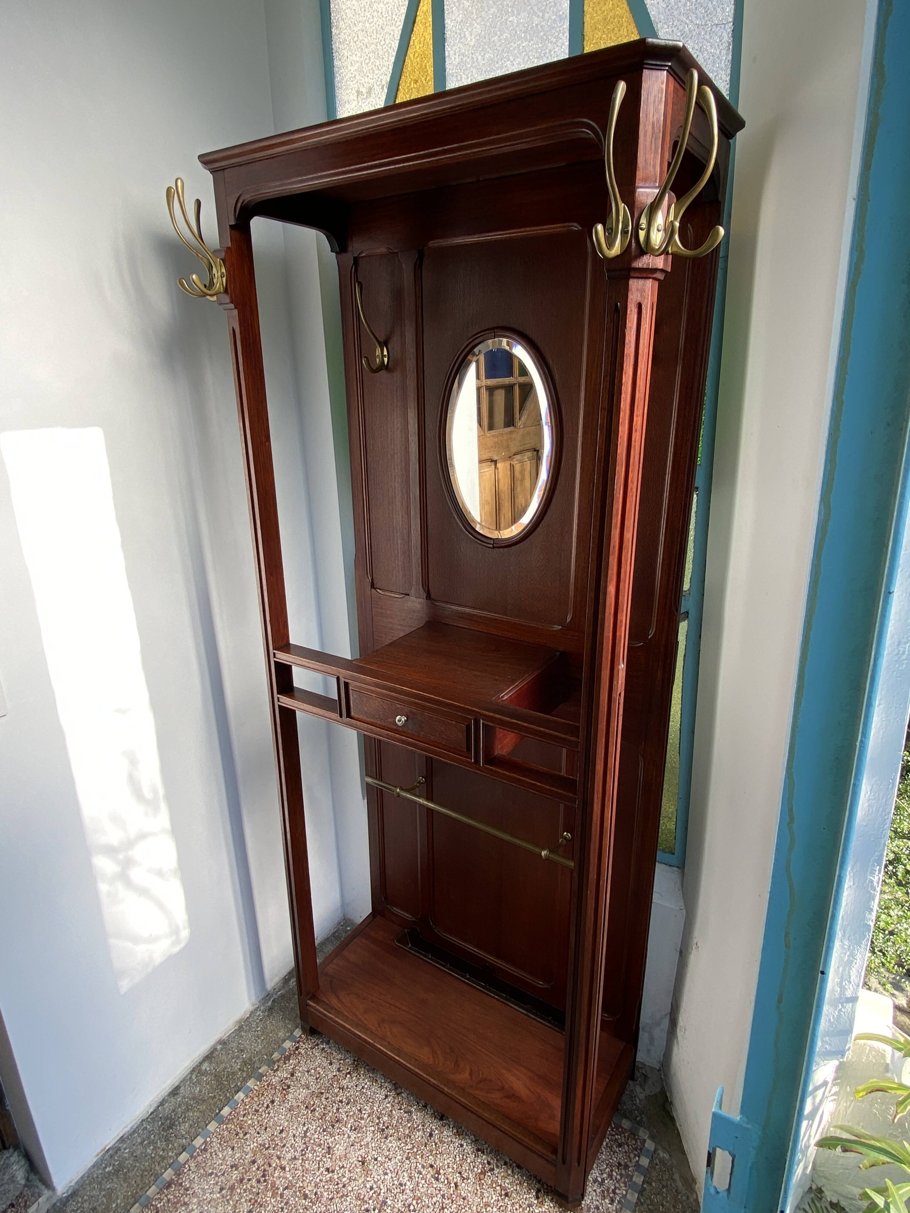 Antique wooden coat rack with mirror and shelf.