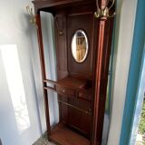 Antique wooden coat rack with mirror and shelf.