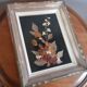 Wood frame dried flowers under glass, black background, vintage