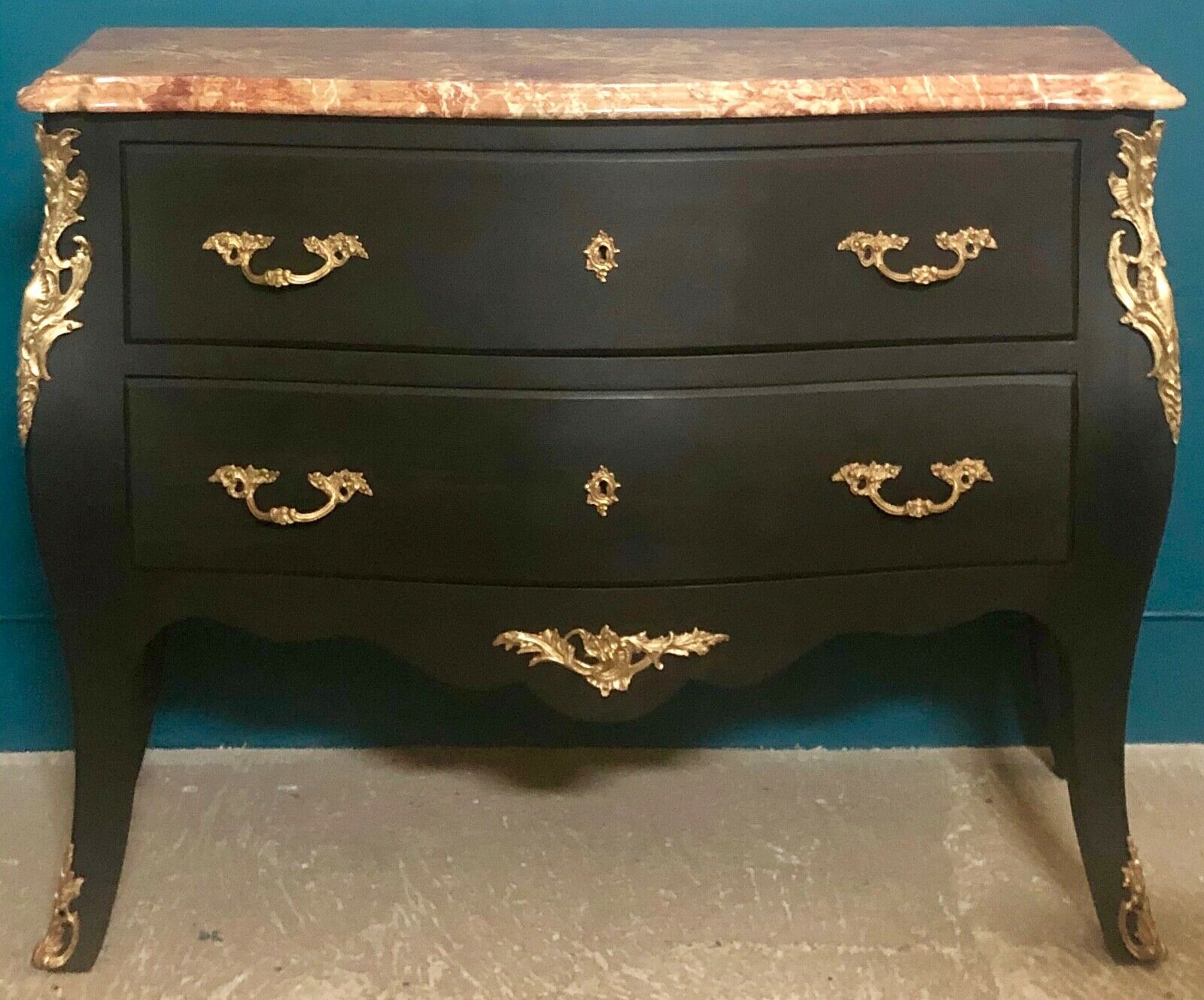 Louis XV style curved black matte commode with gilded bronze ornamentation from the 1950s.