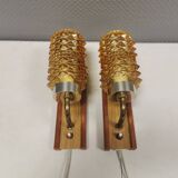 A set of wall lamps in teak wood, with amber colored glass