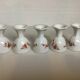 Five old egg cups with orange and grey flowers, polygonal base.