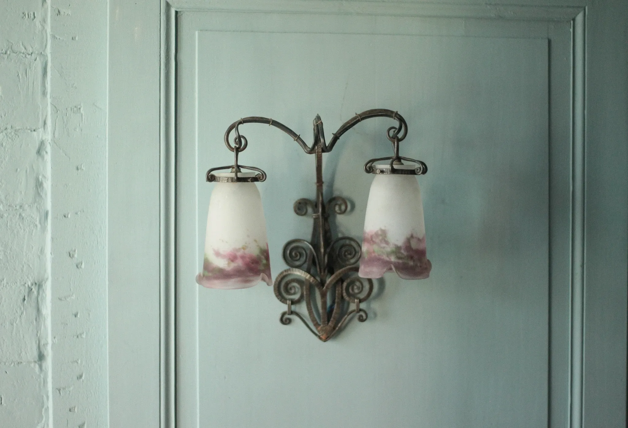 Wall lamp in wrought iron with a pink tulip glass globe by Muller glassworks.