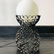 Black wrought iron lamp with a white glass globe.