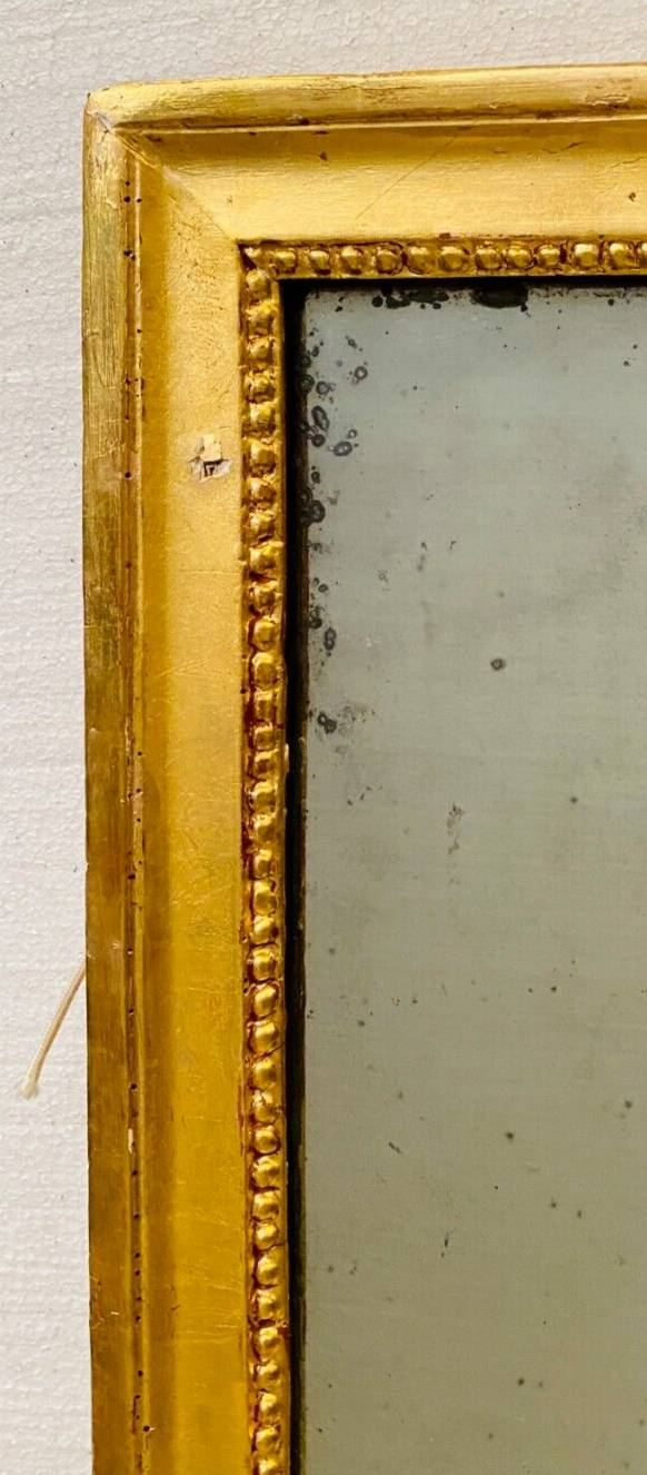 Louis XVI mirror in carved and gilded wood with leaf 18th century