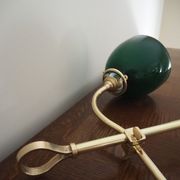 Desk lamp in brass with a swan neck and green opaline glass.