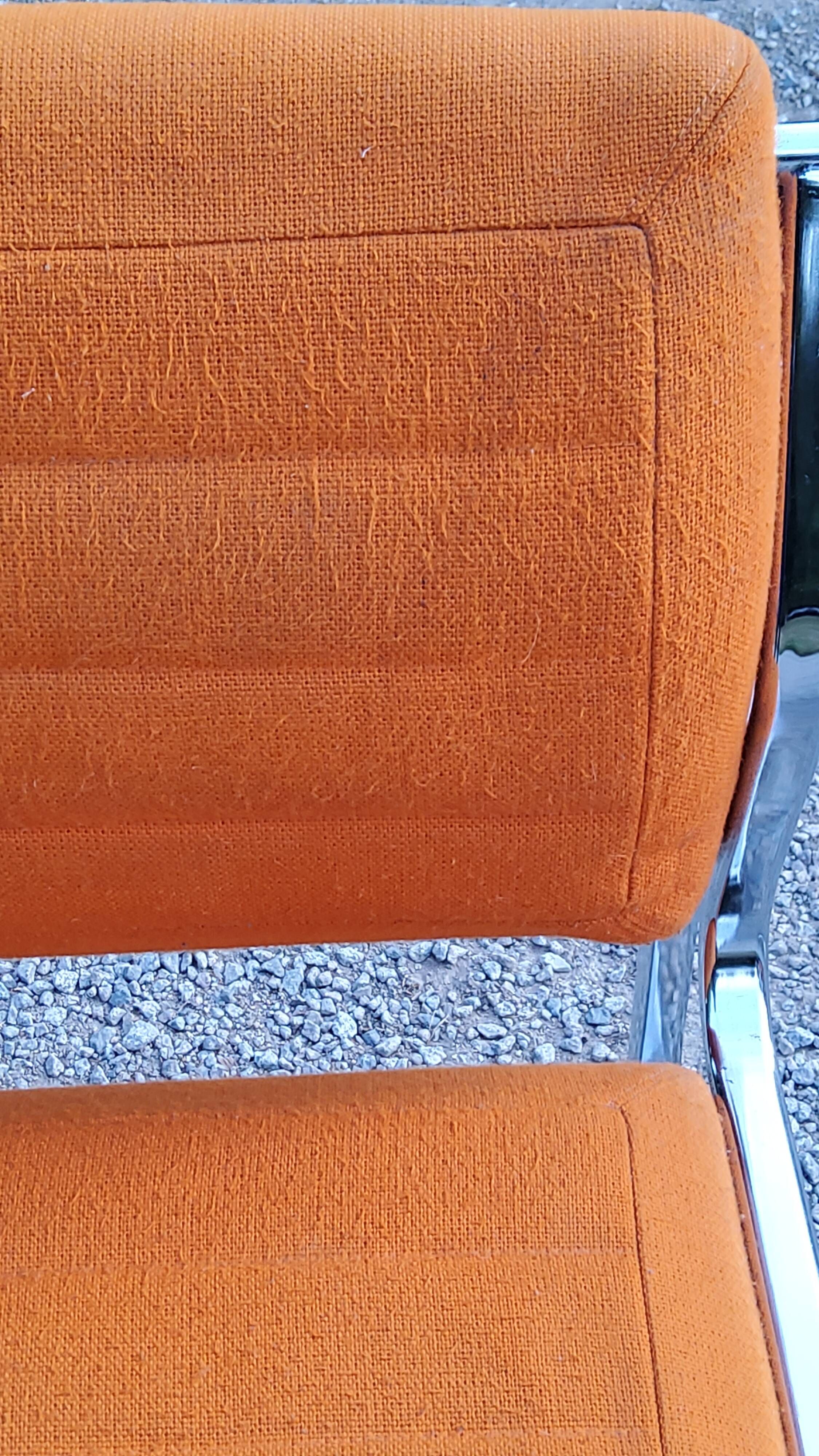 Pair of designer armchairs in orange fabrics and chrome tubes from the 70s