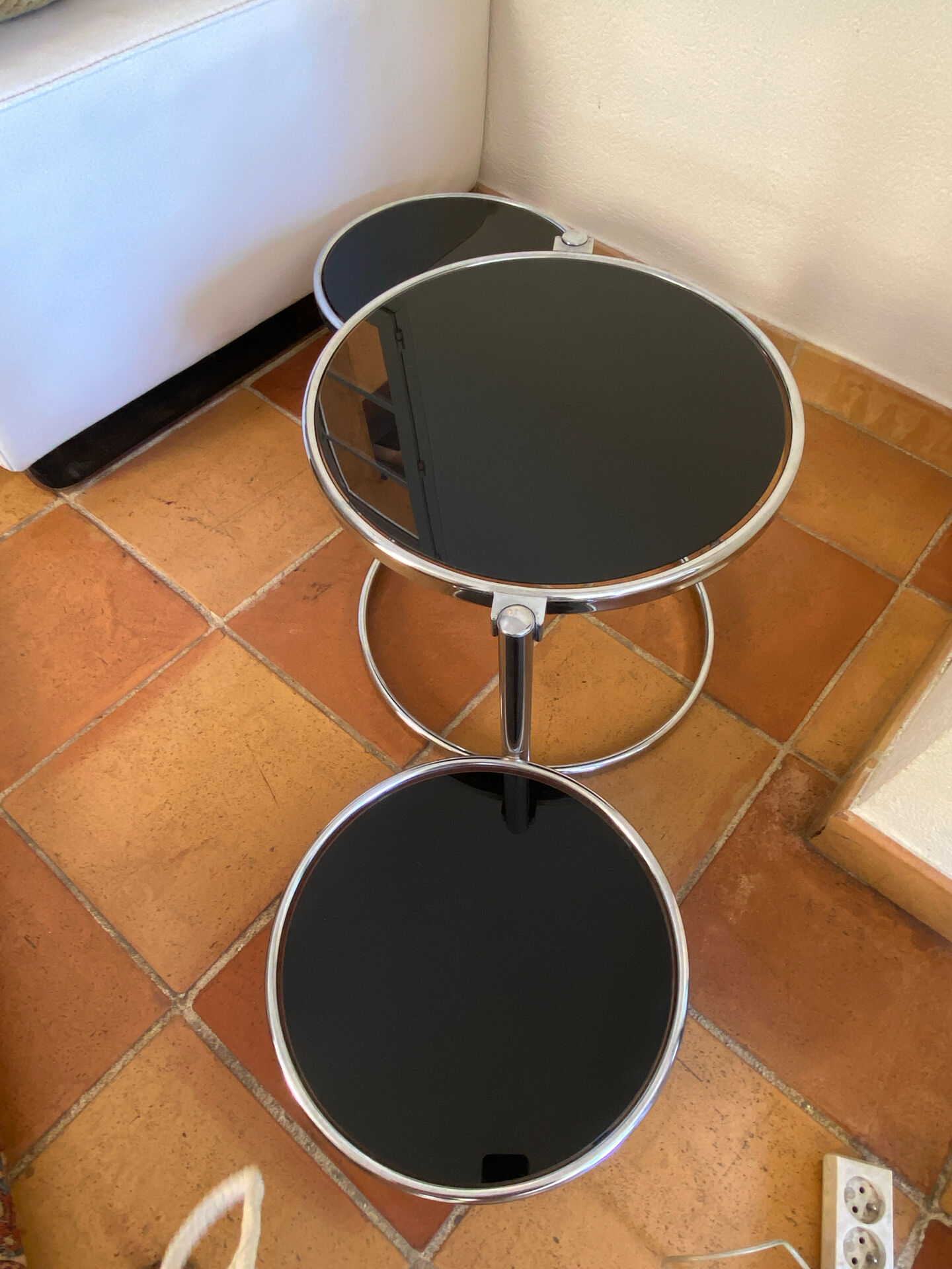 Coffee table with pivoting metal and black glass elements.