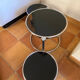 Coffee table with pivoting metal and black glass elements.