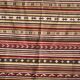 Large Indian rug with red, yellow, and white stripes and geometric fringes.
