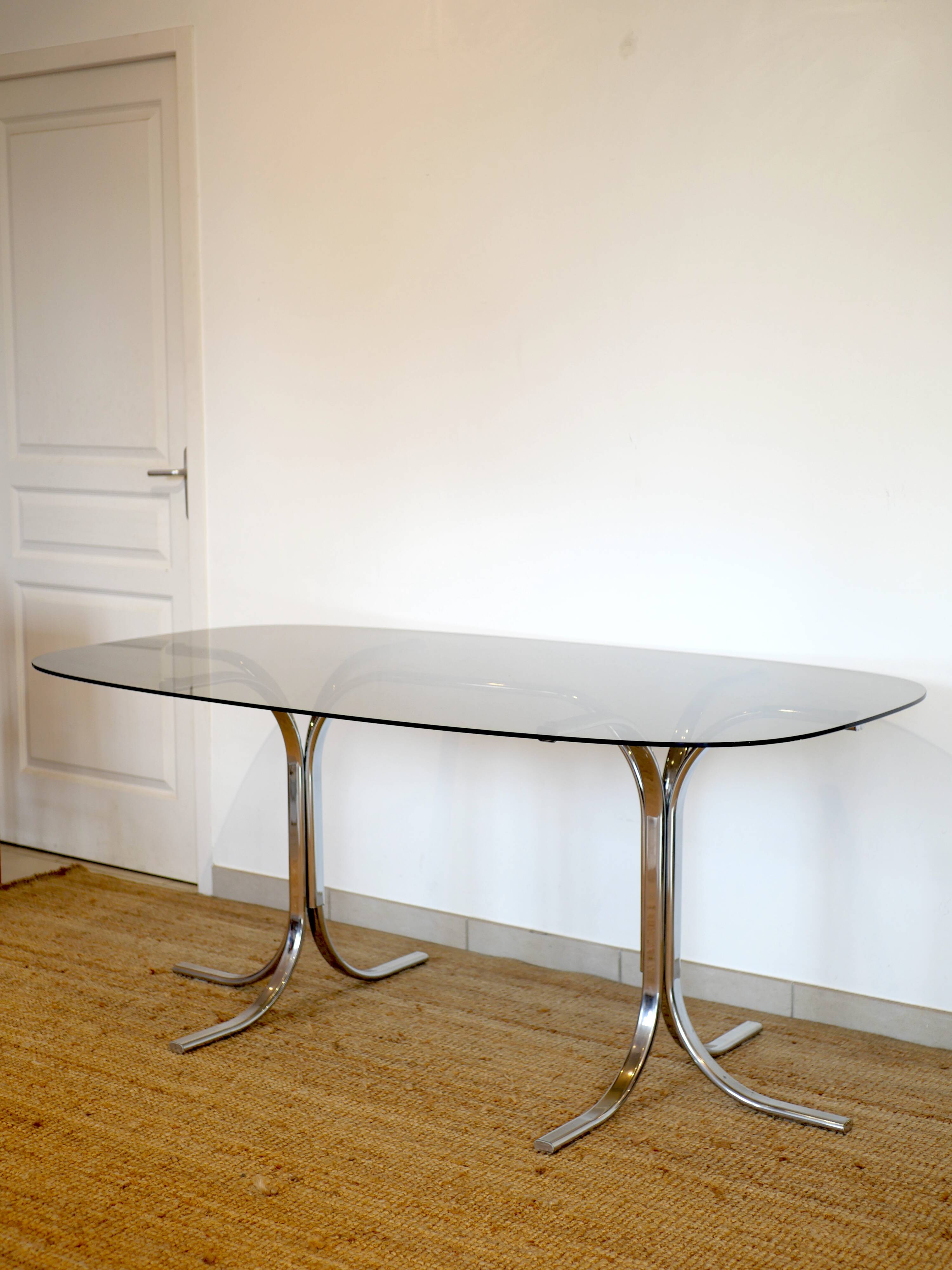 Dining table with smoked glass top and chrome base.