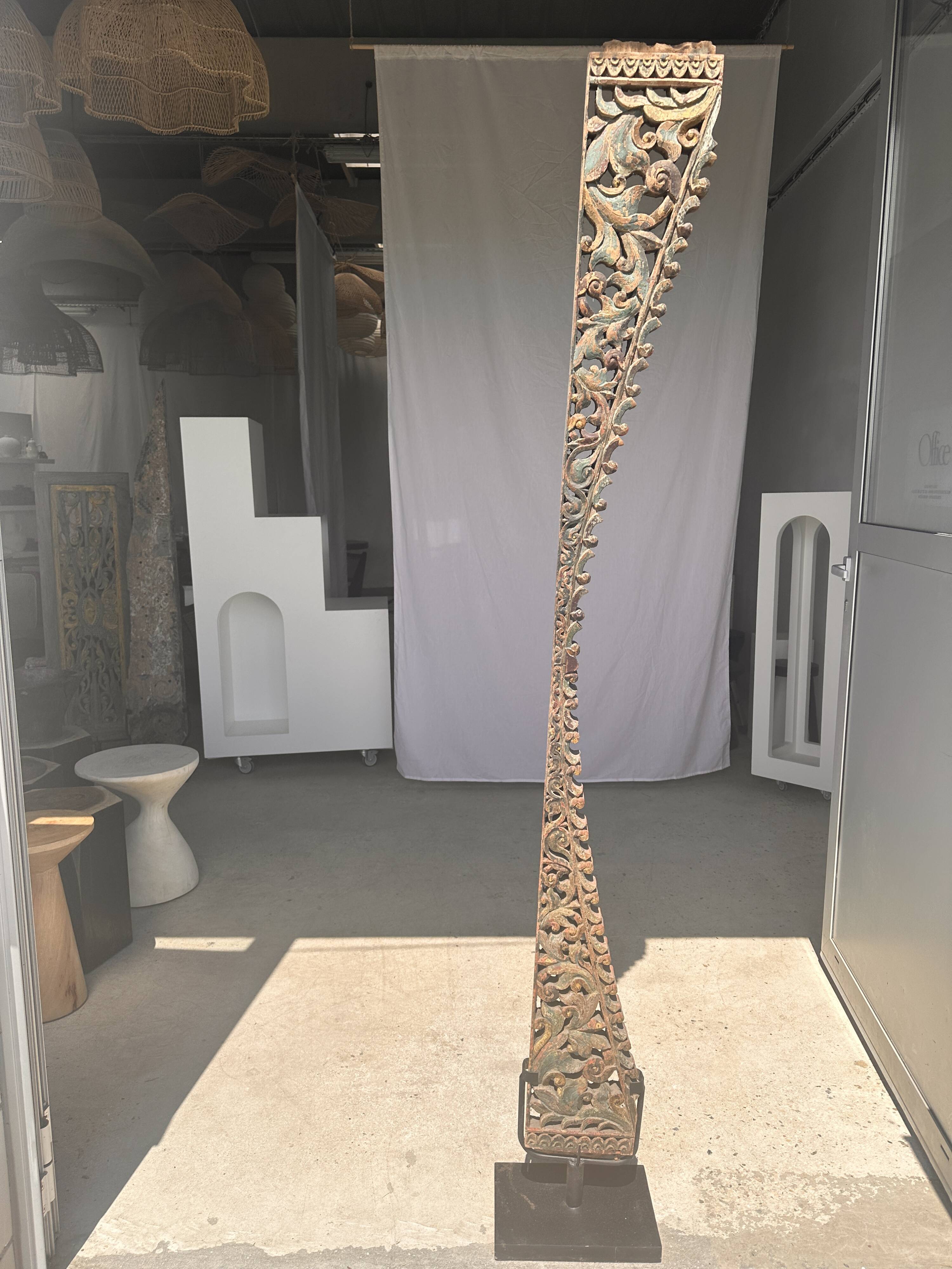 Indonesian construction element in carved wood with intertwined plant motifs mounted on a base (fri