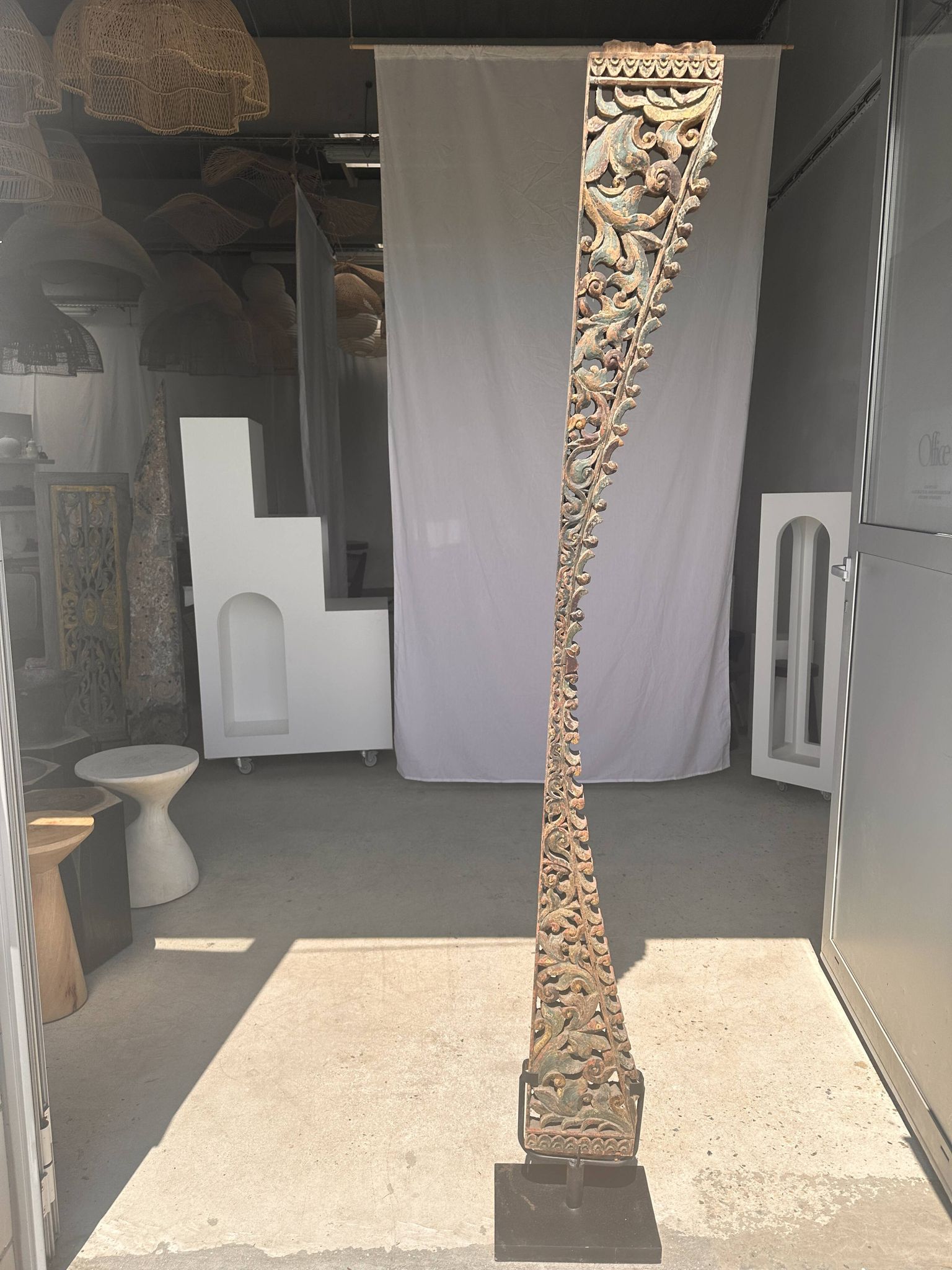 Indonesian construction element in carved wood with intertwined plant motifs mounted on a base (fri