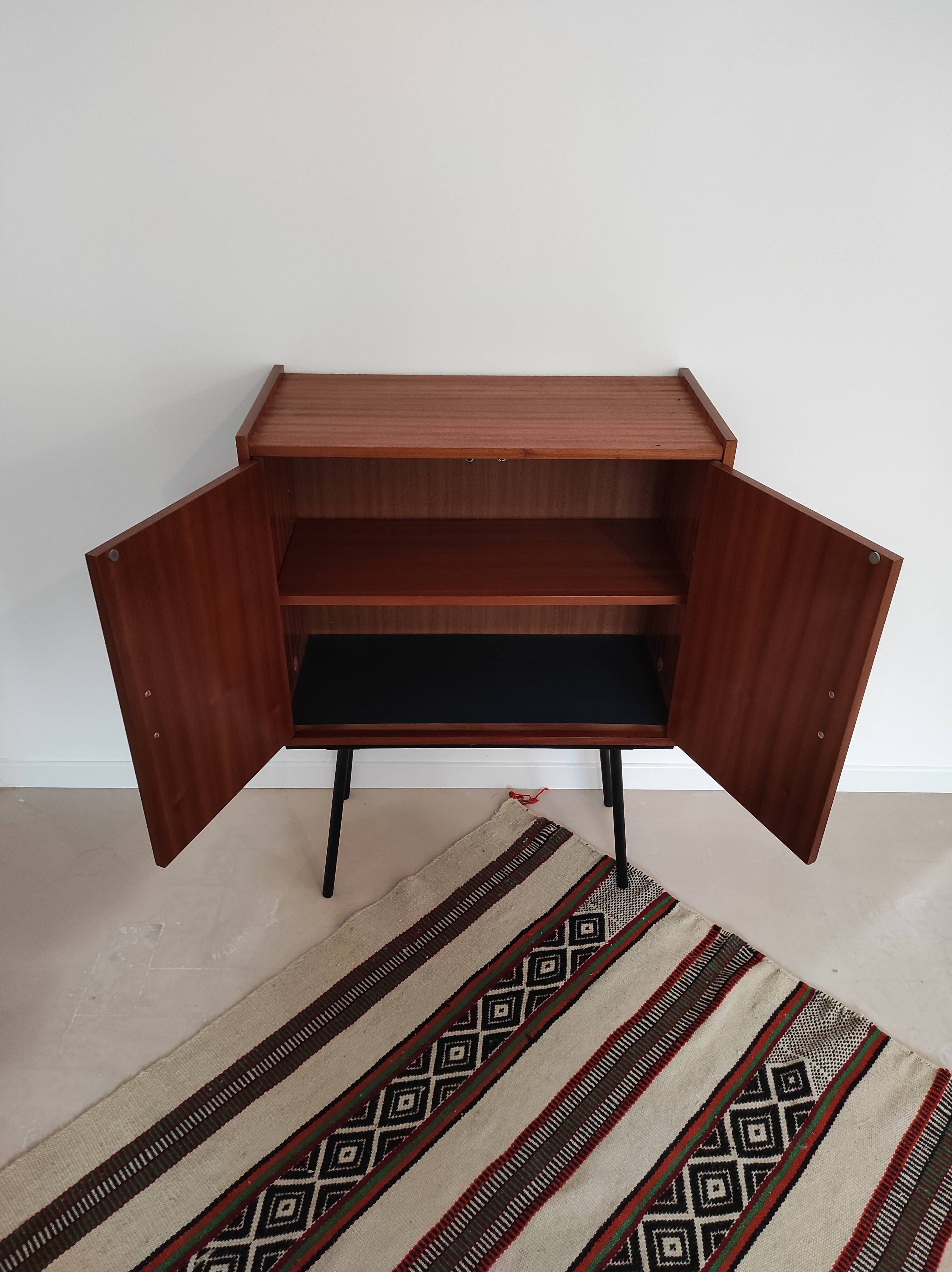 Piece of furniture on high feet metal compass